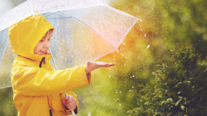 dziecko bawiące się w deszczu