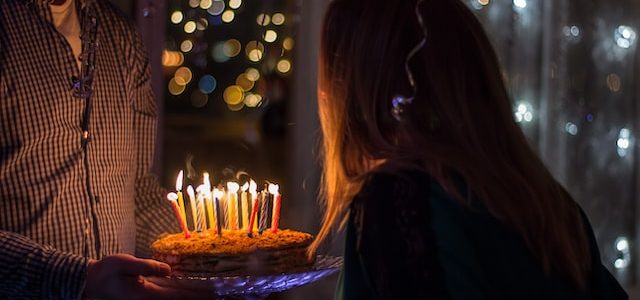 Dziewczyna zdmuchuje świeczki z tortu urodzinowego